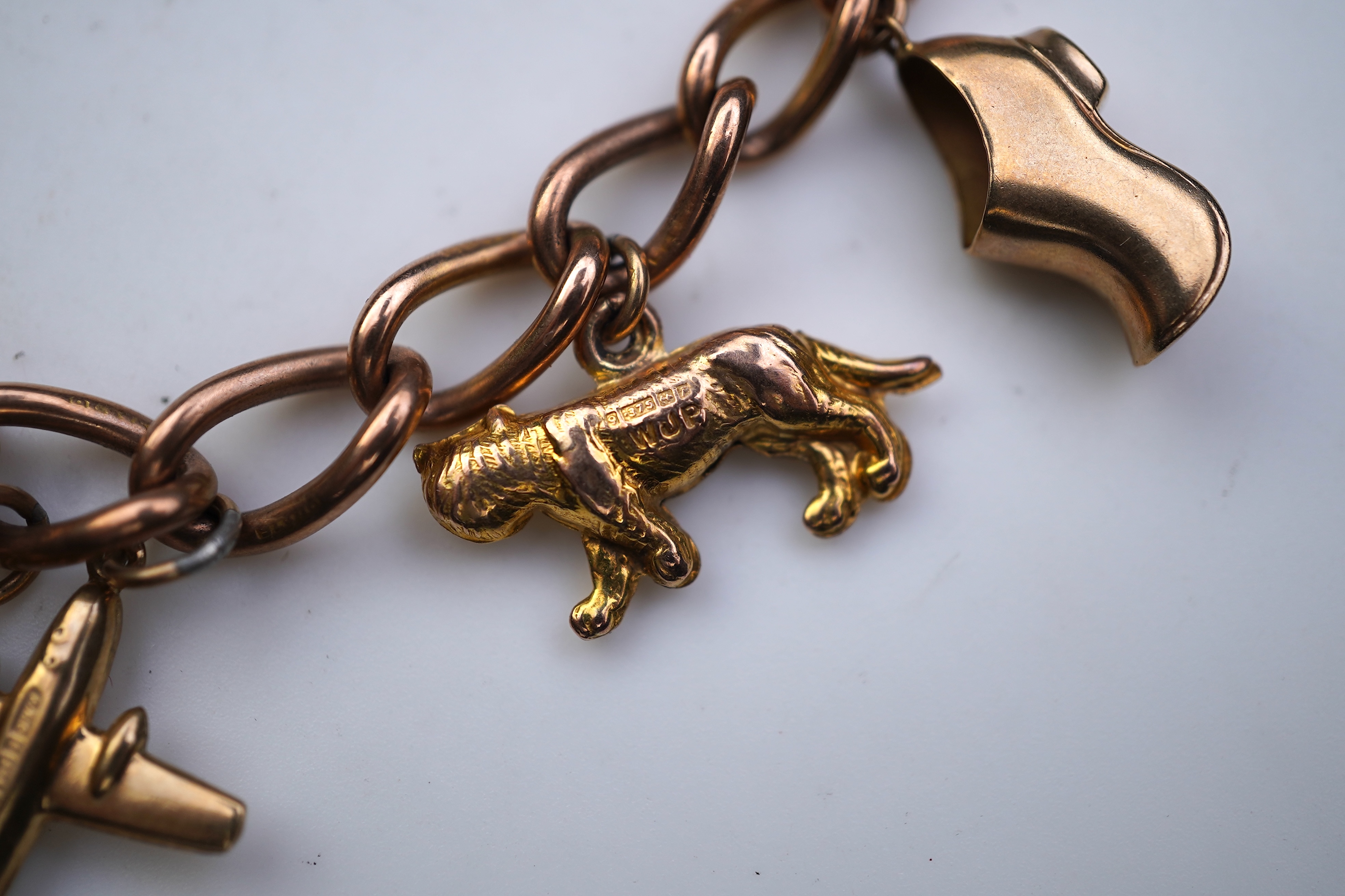 A gold charm bracelet, mid 20th century
